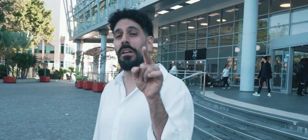 טל ראשון בחולצה לבנה מול מבנה עירוני, מתוך קמפיין מועדון התושבים Rizone